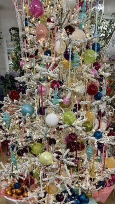 silver christmas tree covered with colorful ornaments