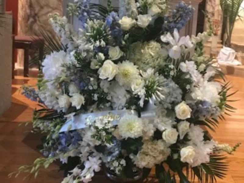 Funeral fresh flower arrangement with white flowers and ribbon