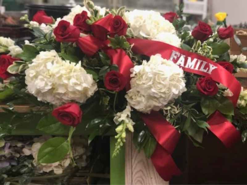 Red and white sympathy fresh floral arrangement with ribbon