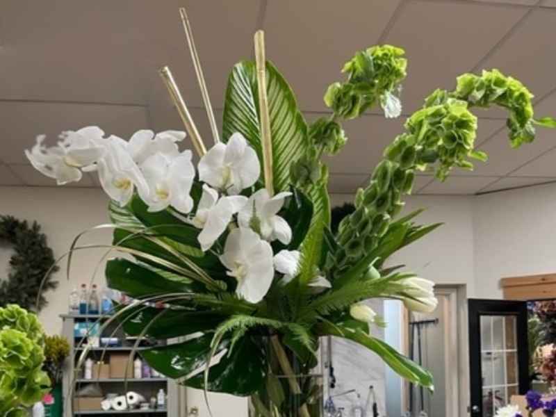 Sympathy arrangement with flowers and leaves
